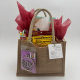 Gift bag with custom wrapped nut free goods with a wood cut ornatment on a white background